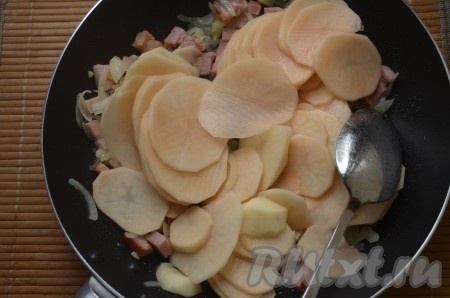 Картофель очистить, нарезать очень тонкими ломтиками, как на фото, аккуратно перемешать с обжаренными беконом, чесноком и луком.