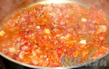 Когда лук с окороком будут почти готовы, добавить к ним натертый на терке помидор.