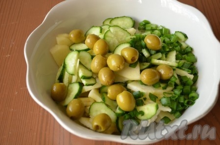 Добавить в салатник зеленые оливки и мелко порезанный зеленый лук.