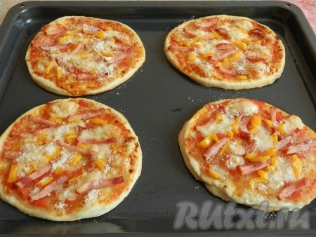 Запекать мини пиццы из слоёного бездрожжевого теста в разогретой духовке при температуре 190-200 градусов 15-18 минут. Готовые пиццы, по желанию, посыпать натёртым пармезаном.