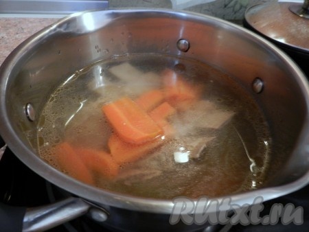 Добавить очищенную луковицу и нарезанную брусочками морковь, варить на медленном огне 1-1,5 часа (до готовности говядины). Готовый бульон процедить, мясо вытащить и отделить от костей, овощи из бульона выбросить.
