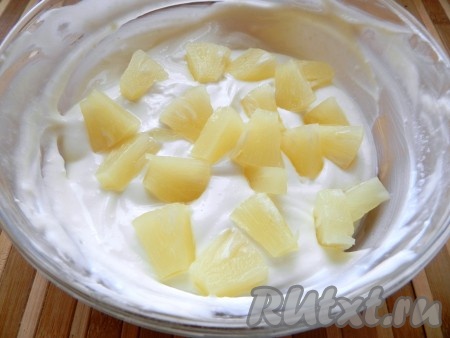Осторожно влить желатин в творожную массу, тщательно перемешать. Добавить кусочки ананасов и снова перемешать.