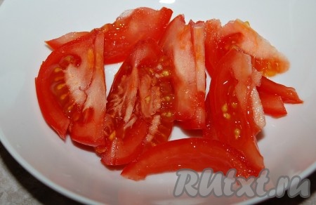 Пока кальмары остывают, нарезать помидоры ломтиками и уложить их в миску.
