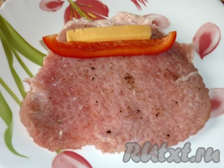 На пласт мяса положить ломтики сыра и перца.
