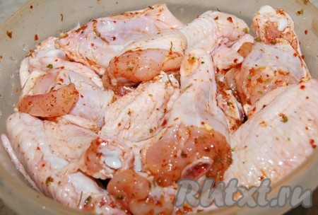 Тщательно перемешать крылышки с аджикой, специями и солью. Оставить на 15 минут, чтобы мясо промариновалось.