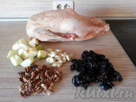 Гуся помыть, высушить, натереть солью снаружи и изнутри. Приготовить начинку: порезанные яблоки, чернослив, орехи, чеснок.
