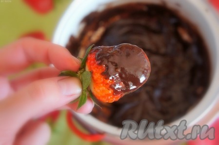 Дайте шоколаду остыть в течение 3-5 минут. Клубнику аккуратно обмакните в шоколад, чтобы шоколад равномерно покрыл ягоду.