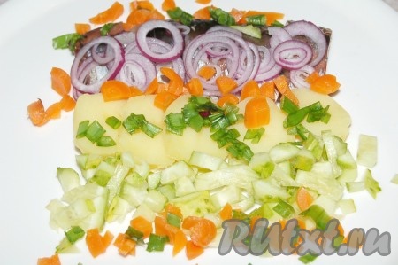 Морковь отварить, очистить, нарезать мелкими кубиками и выложить на тарелку. Добавить мелко нарезанный зеленый лук.