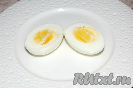 Сварить яйцо вкрутую, очистить его и разрезать на половинки.