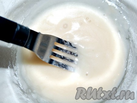 Когда кекс остынет, приготовить глазурь. Для этого всыпать в миску сахарную пудру, добавить к ней воду и взбить с помощью вилки до однородности.