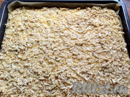 Достать противень из духовки и выложить по всей поверхности пирога ореховую массу.