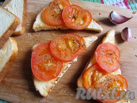 
На каждый ломтик подсушенного хлеба положите 2-3 ломтика горячего запеченного помидора.