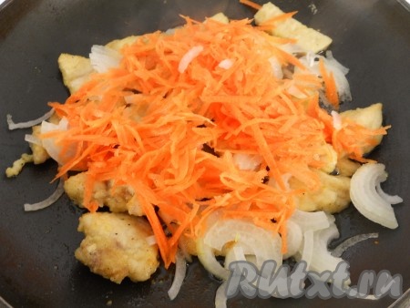 Добавить в сковороду к куриному филе лук, нарезанный на тонкие полукольца, и натёртую на крупной тёрке морковь. 