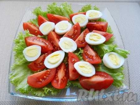 Помидоры вымыть, разрезать на 4 части, перепелиные яйца очистить и нарезать половинками. Яйца и помидоры выложить поверх листьев салата.