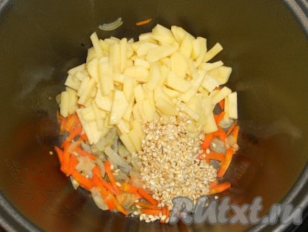 В чашу мультиварки влить растительное масло, выложить лук и морковь, выставить режим "Обжаривание" на 15 минут. После этого добавить в чашу порезанный картофель и промытую перловую крупу.
