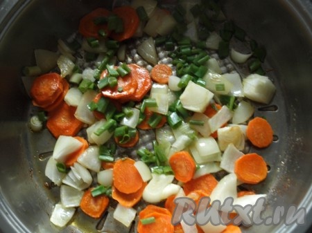 На сковороде с разогретым оливковым (или подсолнечным) маслом на среднем огне обжарить лук и морковь в течение 5-6 минут (лук должен стать прозрачным, а морковь - достаточно мягкой), помешивая, затем добавить нарезанный зелёный лук, перемешать.