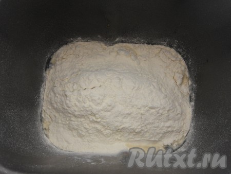 В ведерко хлебопечки влить воду, добавить просеянную муку.