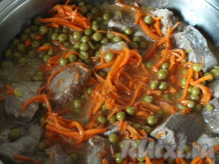 Затем добавляем к говядине консервированный зелёный горошек вместе с жидкостью, томатную пасту, корейскую морковь и тушим под крышкой на маленьком огне 35-40 минут. 
