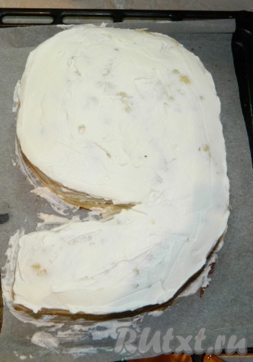 Коржи, смазанные кремом с кусочками персиков, выложить один на другой, формируя торт в виде цифры 9. Обмазать верх и бока торта тонким слоем сливок.