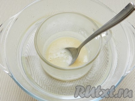 Затем чашку с желатином поставить в миску с горячей водой. Перемешивая желатиновую массу, подержать её в миске с водой, пока кристаллики желатина не растворятся.