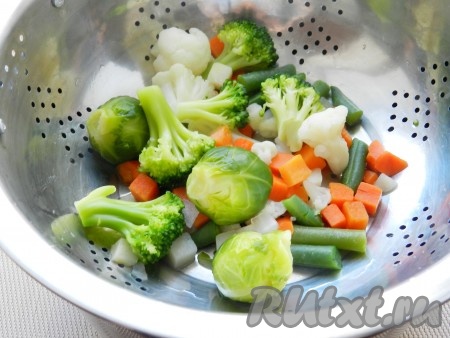 Одновременно отварить в подсоленной воде замороженные овощи в течение 7 минут.