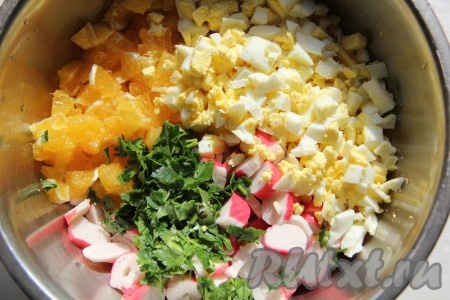 Яйца тоже нарезать на небольшие кубики и вместе с измельчённой зеленью добавить в салат из крабовых палочек и апельсина.
