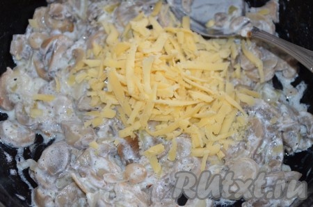 Натереть половину сыра и смешать с грибной начинкой.