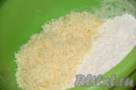 Прежде всего замесим тесто, для этого муку нужно просеять в объёмную миску, добавить сыр, натёртый на мелкой тёрке.