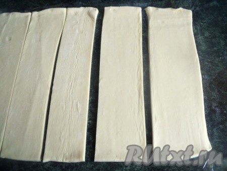 Пласт дрожжевого слоёного теста разморозить, развернуть и разрезать на 6 полосок.