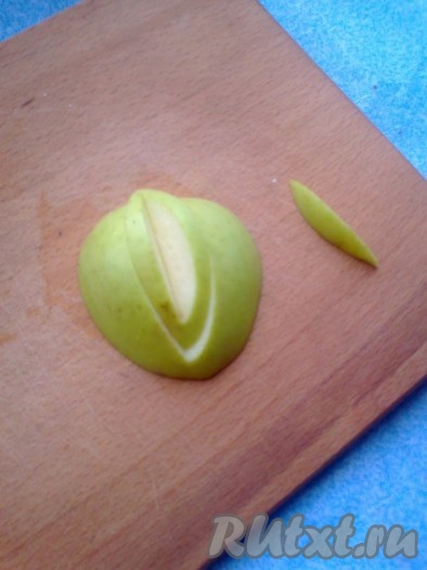 Вырезаем украшения  из яблока. Для этого отрезаем часть яблока (можно половину, если маленькие). Ставим его на разделочную доску разрезом вниз. Теперь симметрично, с любой из сторон яблока начинаем делать разрезы так, чтобы они сходились и образовывался уголок.