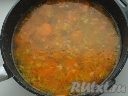 Через 15 минут добавить овощной бульон (или воду) к моркови и луку, довести до кипения, уменьшить огонь и готовить под закрытой крышкой минут 30 (до мягкости моркови).
