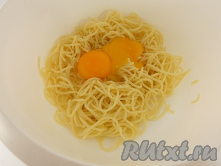 К охлажденным отварным спагетти добавить яйца.