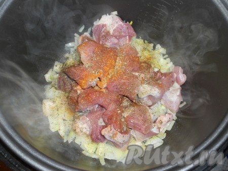 Добавить мясо к луку и готовить на том же режиме еще 10 минут. Затем свинину посолить, поперчить и посыпать специями.