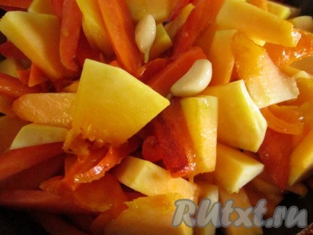 Добавьте к моркови и перцу тыкву и чеснок. Обжаривайте ещё минут 10.