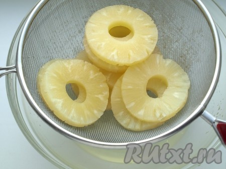 Кольца ананасов следует выложить на сито и дать стечь лишней жидкости. Слегка прижать, чтобы убрать лишний сок.
