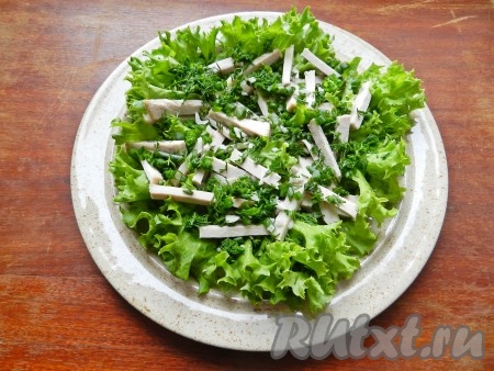 В тарелку выложить вымытые и обсушенные листья салата, предварительно порвав их руками. На салат выложить мясо, зеленый лук и чеснок.