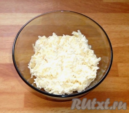 Сыр натереть на средней терке, добавить чеснок, пропущенный через пресс, сметану и перемешать.
