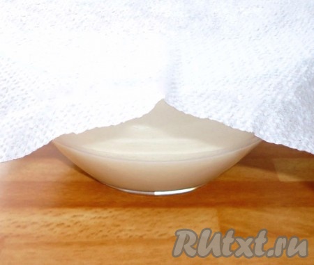 Накрыть миску полотенцем (или салфеткой), поставить в тёплое место на 10-15 минут, за это время дрожжи начнут работать и поверхность молочно-дрожжевой смеси запузырится.