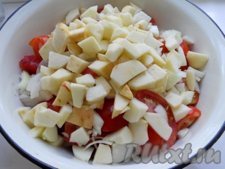 Яблоки очистить от кожицы и семян, нарезать и добавить к помидорам и луку.