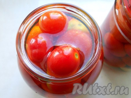 Залить помидорчики кипящей водой, накрыть банки простерилизованными крышками и оставить на 30 минут.