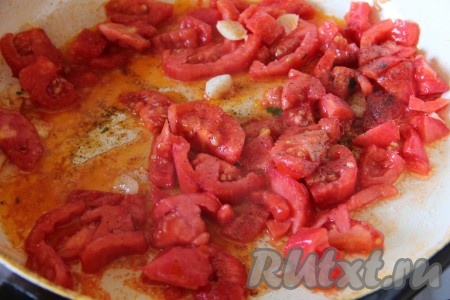 К обжаренному чесноку добавить нарезанные на дольки помидоры, посолить по вкусу.