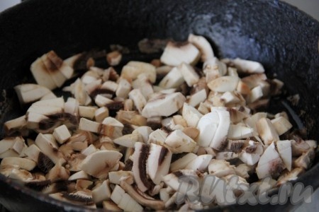 Очищенный лук и шампиньоны мелко нарезаем, выкладываем на сковороду, разогретую с растительным маслом, и обжариваем на среднем огне, иногда перемешивая, в течение 5-7 минут (до золотистого цвета грибов и лука). Если вы готовите с лесными грибами, то их нужно перед обжаривание отварить в течение минут 20.
