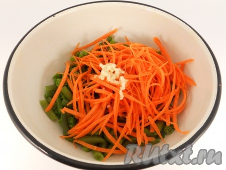 Добавить морковь, натертую на терке для корейской моркови, и чеснок, пропущенный через пресс.
