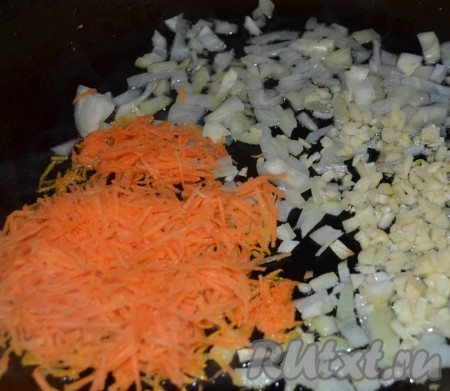 Разогрейте духовку до 180 градусов. Очистите и мелко нарежьте лук и чеснок, морковь натрите на терке. Нагрейте оливковое масло в большой сковороде на среднем огне. Добавьте лук, чеснок, морковь, орегано и жарьте 5 минут до мягкости.

