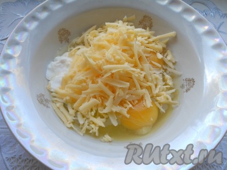 К яйцам добавить сметану и натертый на крупной терке твердый сыр. Хорошенько все перемешать венчиком. Посолить по вкусу.
