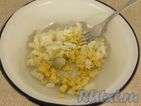Яйца отварить в течение 9-10 минут после закипания воды, полностью остудить их и очистить. Отделить белки от желтков. Желтки переложить в миску, размять вилкой, добавить сыр, натёртый на крупной тёрке (я готовила с брынзой, поэтому просто размяла её вилкой).