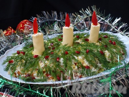 Салат посыпаем натёртыми яйцами, в ряд ставим подготовленные сырные свечи, в центр каждой свечки вставляем огонь из перца. Покрываем верх салата маленькими веточками укропа и посыпаем гранатовыми зёрнами. Яркий, вкусный салат "Рождественские свечи" можно подавать к столу. 