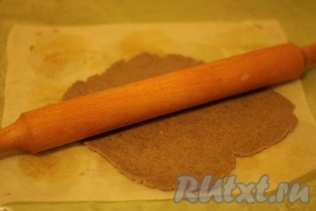 Раскатываем на пекарской бумаге тесто для ржаного печенья толщиной 3 мм.
