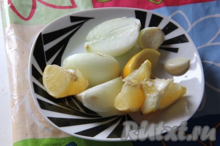 Лук, лимон и чеснок почистить, крупно порезать и поместить внутрь курицы.