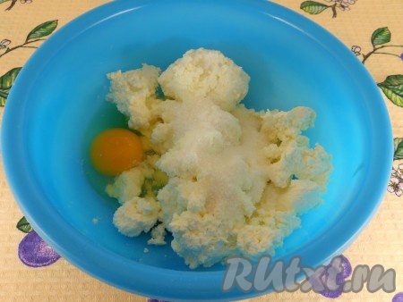 Для приготовления начинки творог выложить в миску. К творогу добавить яйцо, всыпать сахар.